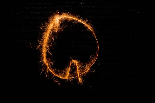 Písmeno Q z prskavky na černém pozadí — Stock fotografie