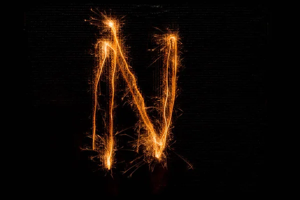 Letter N made of sparklers on black — Stock Photo, Image