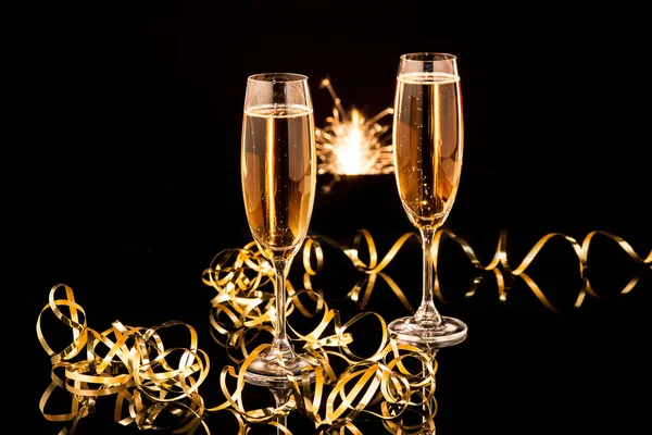 Vasos con champán contra luces navideñas — Foto de Stock