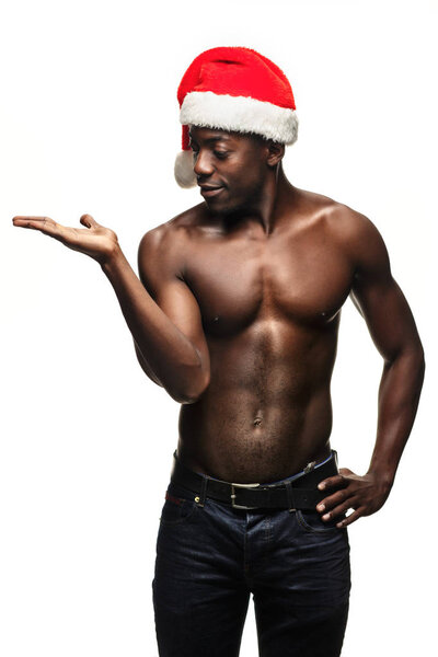 Молодой человек без рубашки в шляпе Санта Клауса
