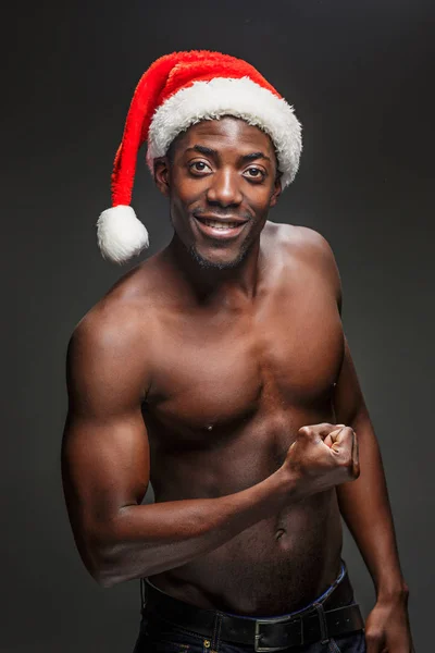 Musculoso negro sin camisa joven en Santa Claus sombrero — Foto de Stock