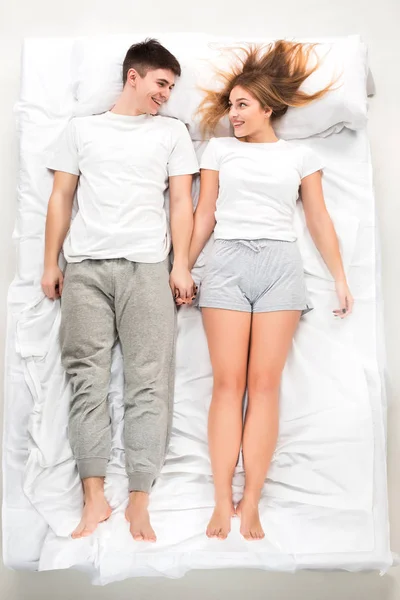 Det unga vackra paret liggande i en säng — Stockfoto