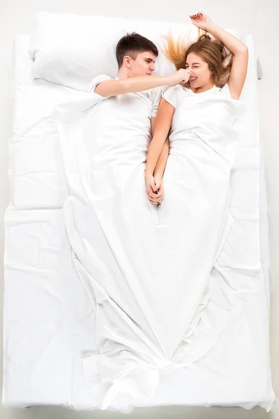 O jovem casal adorável deitado em uma cama — Fotografia de Stock