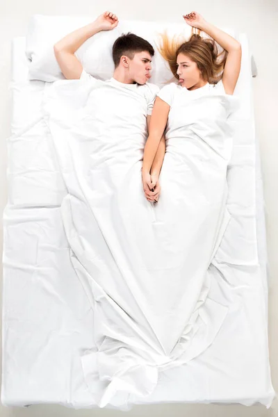 O jovem casal adorável deitado em uma cama — Fotografia de Stock