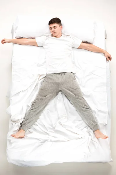 El joven acostado en una cama —  Fotos de Stock