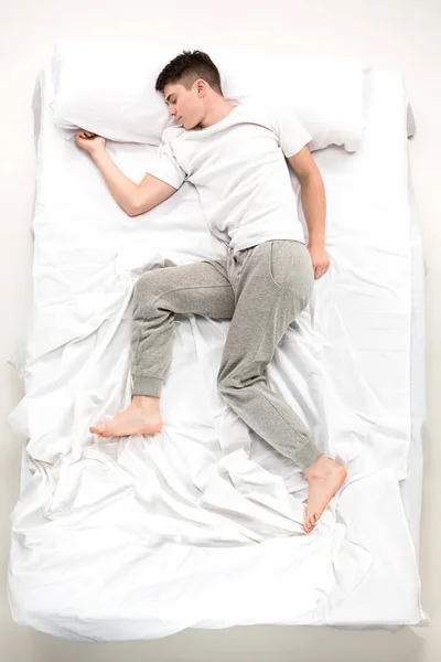 Der junge Mann liegt im Bett — Stockfoto