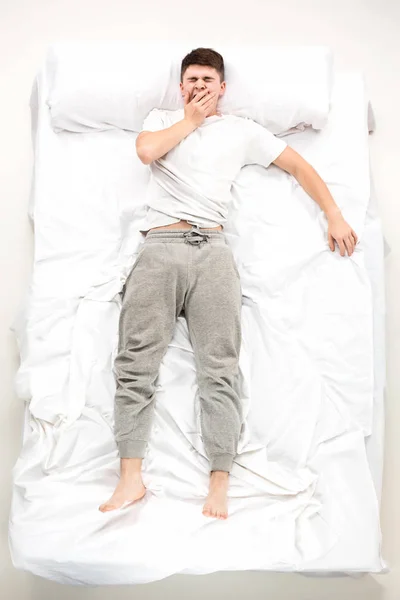 El joven acostado en una cama — Foto de Stock