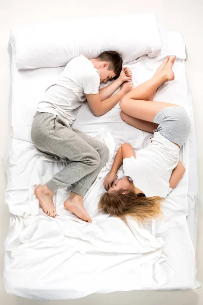 Le jeune couple charmant couché dans un lit — Photo