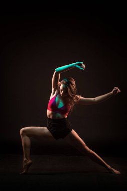 Siyah arka plan üzerine dans bej elbise genç güzel dansçı