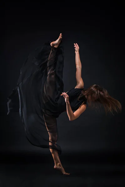 年轻漂亮的舞伴在米色的衣服，在黑色背景上跳舞 — 图库照片