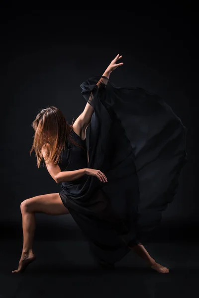 Jovem bela dançarina em vestido bege dançando em fundo preto — Fotografia de Stock