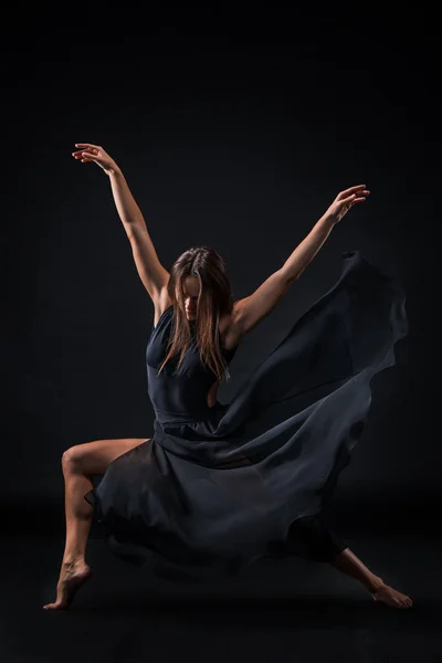 Giovane bella ballerina in abito beige che balla su sfondo nero — Foto Stock