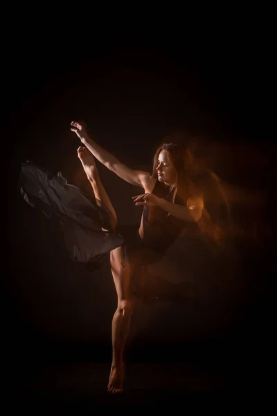 Joven hermosa bailarina en vestido beige bailando sobre fondo negro — Foto de Stock