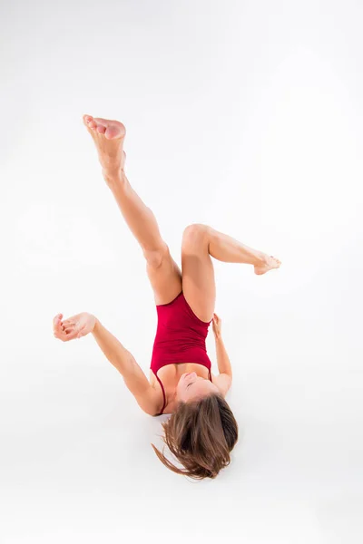 Jonge mooie danseres in beige jurk dansen op witte achtergrond — Stockfoto