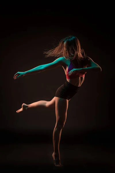 Молодий красивий танцюрист у бежевій сукні танцює на чорному тлі — стокове фото