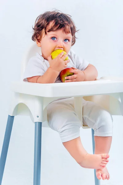 Menino feliz sentado e comendo — Fotografia de Stock