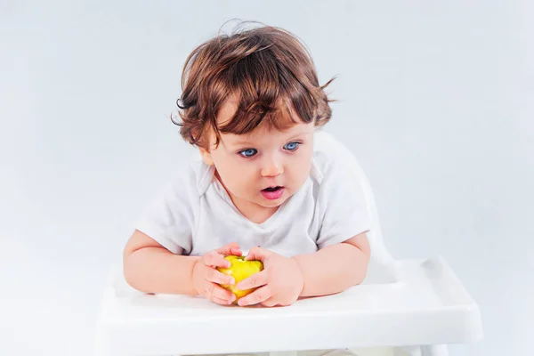 Niño feliz sentado y comiendo — Foto de Stock