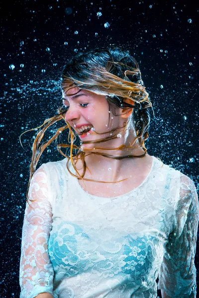 Mladá dívka stojící pod tekoucí vodou — Stock fotografie