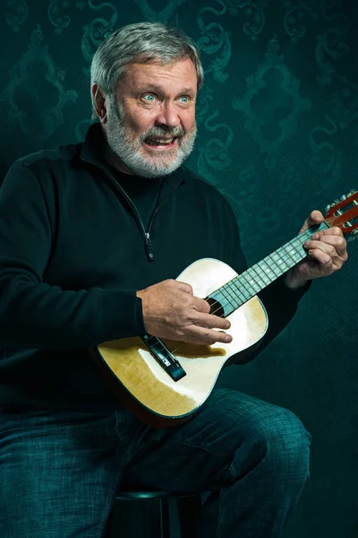 Студийный портрет старшего человека с гитарой . — стоковое фото