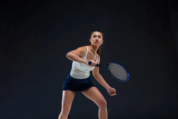 Porträtt av vacker flicka tennisspelare med en racket på mörk bakgrund — Stockfoto