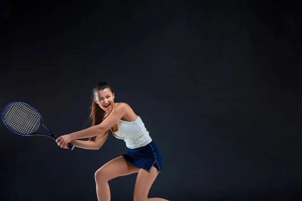 Porträtt av vacker flicka tennisspelare med en racket på mörk bakgrund — Stockfoto