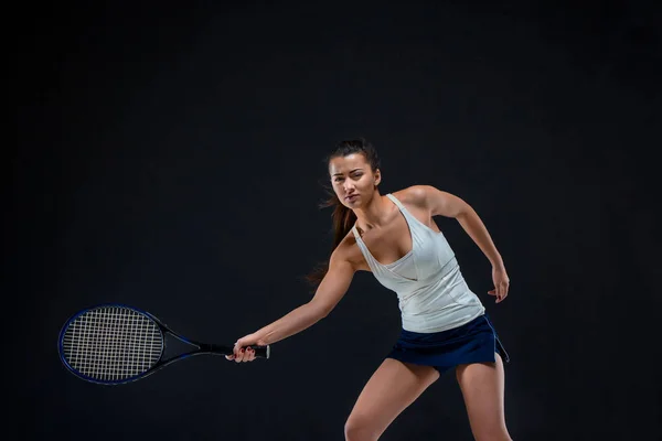 Portret van mooi meisje tennisspeler met een racket op donkere achtergrond — Stockfoto