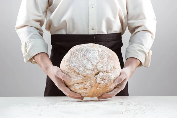 Baker homem segurando pão orgânico rústico em mãos — Fotografia de Stock