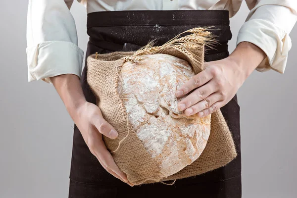 Человек-пекарь держит в руках рустик органического хлеба. — стоковое фото