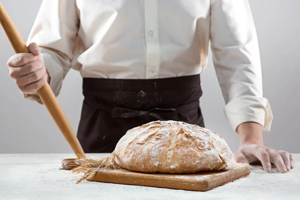 A férfi kezét és rusztikus szerves vekni kenyér — Stock Fotó