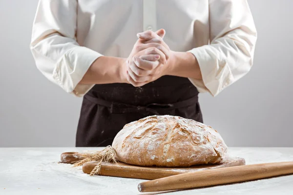 Le mani maschili e la pagnotta rustica biologica del pane — Foto Stock