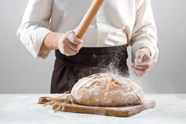 A férfi kezét és rusztikus szerves vekni kenyér — Stock Fotó