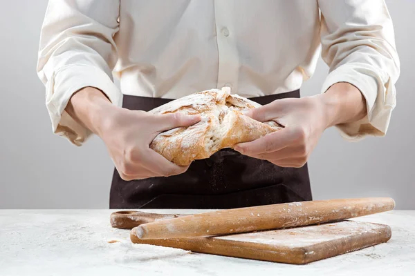 Baker man met rustieke biologische brood in handen — Stockfoto