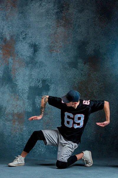 Jonge man break dancing op muur achtergrond. — Stockfoto