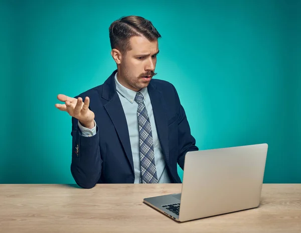 Triste jovem trabalhando no laptop na mesa — Fotografia de Stock