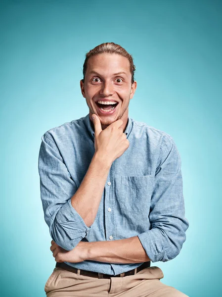 Happy opgejaagd jonge man die lacht op blauwe achtergrond — Stockfoto