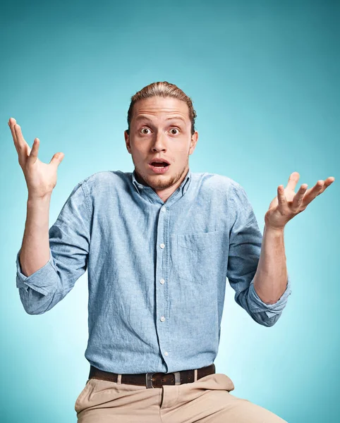 El joven sorprendido sobre fondo azul — Foto de Stock