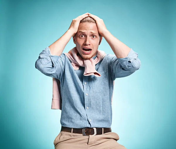 El joven sorprendido sobre fondo azul —  Fotos de Stock