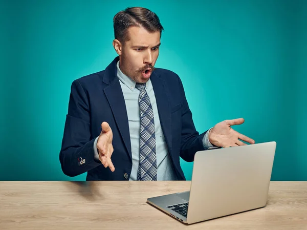 Üzgün genç adam masada dizüstü bilgisayarda çalışma — Stok fotoğraf