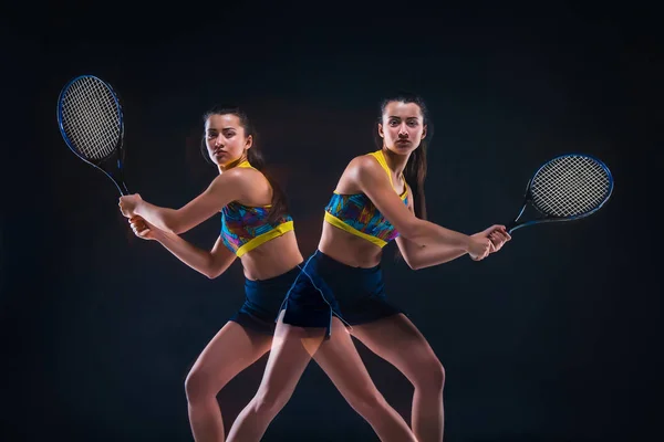 Портрет красивой теннисистки с ракеткой на темном фоне — стоковое фото