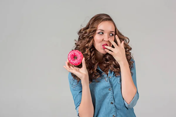 Gadis tersenyum di latar belakang studio abu-abu dengan kue bundar — Stok Foto