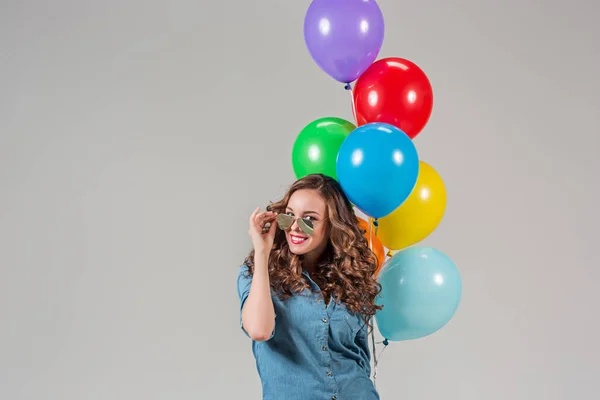 Flicka med solglasögon och gäng färgglada ballonger — Stockfoto