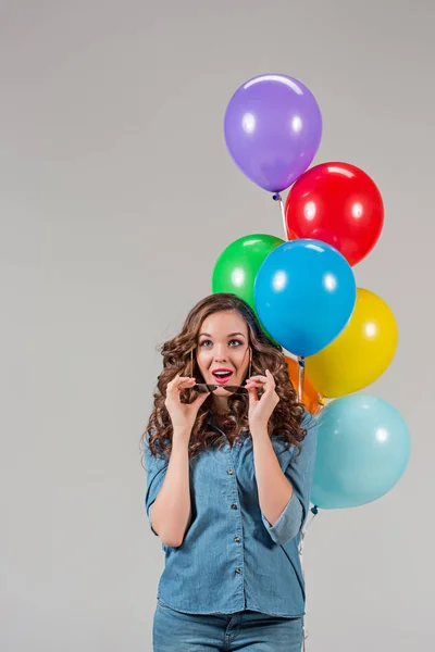 Flicka med solglasögon och gäng färgglada ballonger — Stockfoto