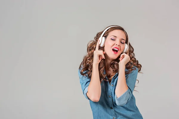 Glad ung kvinna lyssnar musik med hörlurar. — Stockfoto