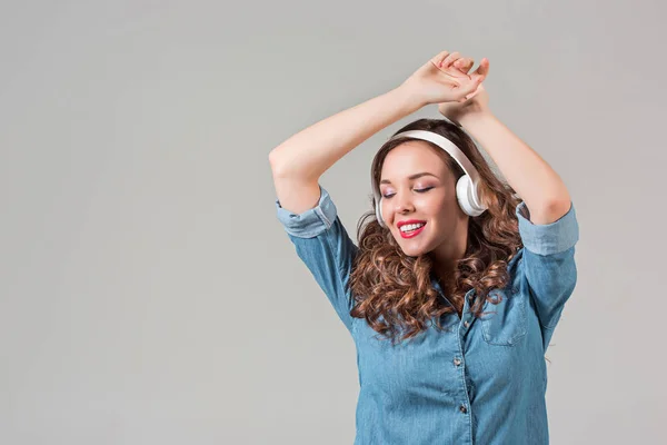 Glad ung kvinna lyssnar musik med hörlurar. — Stockfoto