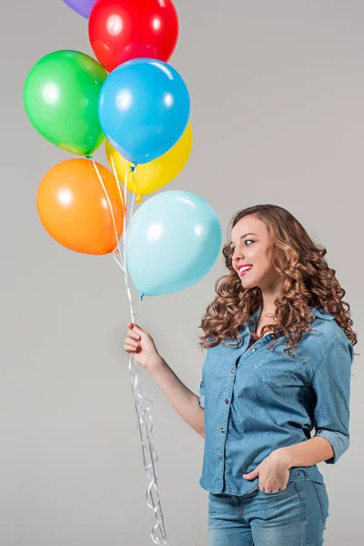 Menina com bando de balões coloridos — Fotografia de Stock