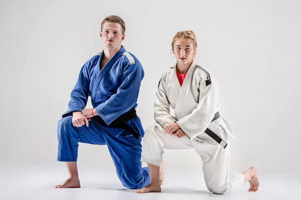 De twee judokas strijders die zich voordeed op grijs — Stockfoto
