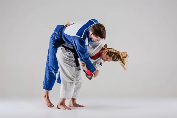 The two judokas fighters posing on gray — Stock Photo, Image