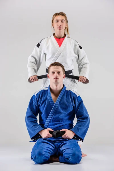 De två judokas fighters poserar på grå — Stockfoto