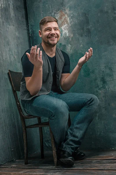 Portrait of smiling happy man sitting on the chair in studio — Stock Photo, Image