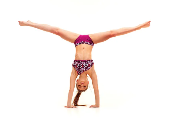 Beyaz arka plan üzerinde izole jimnastik egzersizleri yapıyor genç kız — Stok fotoğraf